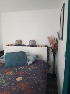 um quarto com uma cama e um vaso com flores em APPT Cosy entier avec piscine em Toulouse