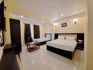 ein Hotelzimmer mit 2 Betten und einem Schreibtisch in der Unterkunft Snow White Retreat Hotel and Restaurant in Gangtok