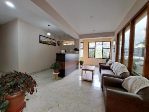 uma sala de estar com dois sofás e uma mesa em Snow White Retreat Hotel and Restaurant em Gangtok