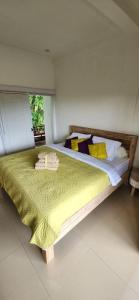 1 dormitorio con 1 cama grande con manta verde en Yobi House, en Ubud