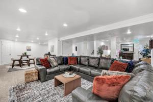 uma sala de estar com um sofá de couro e uma mesa em CR East River House em De Pere