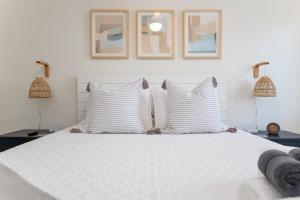 sypialnia z białym łóżkiem z poduszkami i 2 lampami w obiekcie Be A Nomad 2 br Close to the Beach w mieście Jacksonville Beach