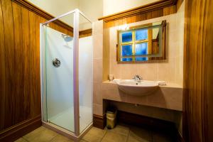 a bathroom with a glass shower and a sink at Shady Rest Bed & Breakfast in Takaka