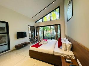 戴维格Coco Palms Resort, Diveagar的一间卧室配有一张床铺,婴儿坐在床上