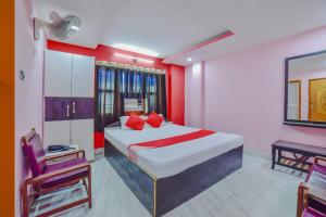 a bedroom with a bed with red and white walls at OYO Flagship 80963 The Subhadra in Muzaffarpur