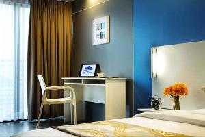 a bedroom with a desk and a bed with a laptop at Pillows Hotel Cebu in Cebu City