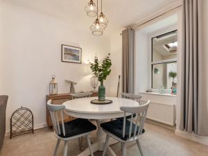 a dining room with a white table and chairs at Y Ty Glas in New Quay