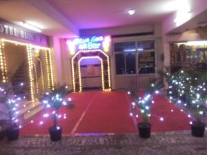 a room with a red carpet and a neon sign at Hotel Blue Star in Coimbatore