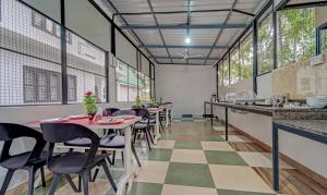 ein Restaurant mit Tischen, Stühlen und Fenstern in der Unterkunft Treebo Trend Regalia Inn Civil Station in Kalpatta