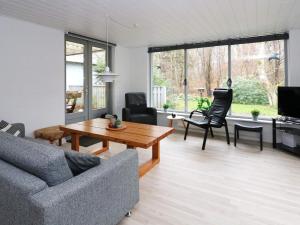uma sala de estar com um sofá e uma mesa em Holiday home Hadsund CXXI em Hadsund
