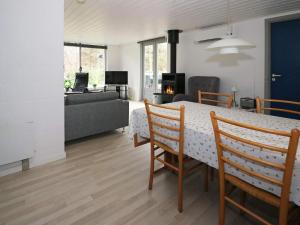 uma sala de jantar e sala de estar com mesa e cadeiras em Holiday home Hadsund CXXI em Hadsund