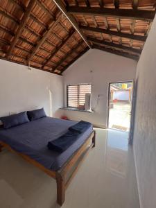 a bedroom with a bed in a room with a window at Revibe Beach Hostel Gokarna in Gokarna