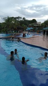 a group of people swimming in a swimming pool at C104-AP-ALDEIA DO LAGO COM COZINHA , CHURRASQUEIRA e bebidas liberadas no parque aquático, internet banda larga, ponto recarga carro elétrico in Caldas Novas