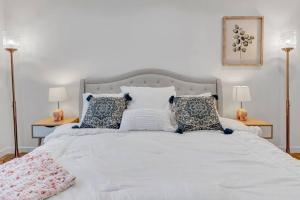 een slaapkamer met een wit bed met kussens en 2 lampen bij Stellar NoHo Art home with new design in Los Angeles