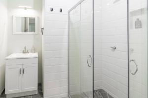 een witte badkamer met een douche en een wastafel bij Casa Marina: Habitación Chiapas in Acámbaro