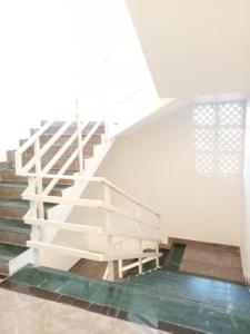 eine weiße Treppe in einem Gebäude mit Glasboden in der Unterkunft Hotel Grand Residency , Kolegaon in Dive