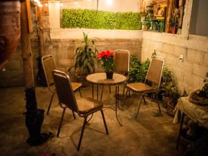 a table and chairs with a red flower in a vase at La Carreta Rica in Zitácuaro