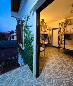 um quarto com uma varanda com uma planta verde em Sabai Sabai Backpackers Hostel em Luang Prabang