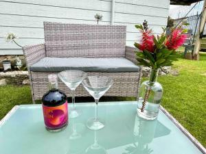 a glass table with glasses and a bottle of wine at Kangaroo Island Seabright Garden Cottage in Kingscote
