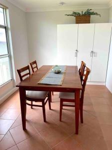 a wooden table and chairs in a room at Kangaroo Island Seabright Garden Cottage in Kingscote