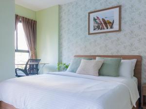 ein Schlafzimmer mit einem großen Bett mit weißer Bettwäsche in der Unterkunft YES! LaCasita Pool View 3 FREE WiFi near the sea in Hua Hin