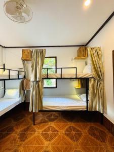 2 łóżka piętrowe w pokoju z oknem w obiekcie Sabai Sabai Backpackers Hostel w mieście Luang Prabang