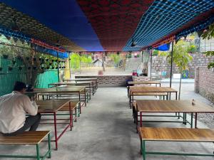 um homem sentado numa mesa num restaurante em The Best Memory Camp em Rishikesh