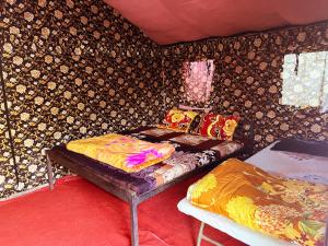 um pequeno quarto com uma cama e uma mesa em The Best Memory Camp em Rishikesh