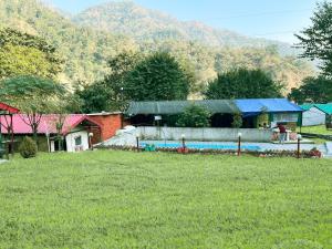 uma casa com piscina num campo de relva em The Best Memory Camp em Rishikesh