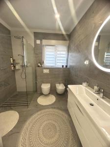 ein Bad mit einer Dusche, einem WC und einem Waschbecken in der Unterkunft Family friendly house with a swimming pool Sibenik - 21484 in Šibenik