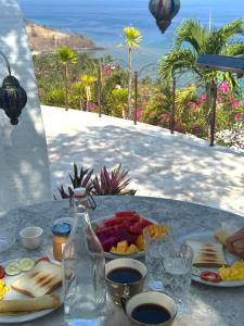 a table with a plate of food and a bottle at Villa Dreamdome in Teluk Nara