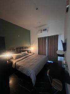 a bedroom with a large bed with a green wall at GUEST INN HOTEL in Dubai