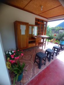 Habitación con sillas, mesa y algunas flores en Hospedaje Pinky Lodge en Oxapampa