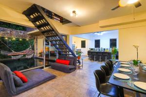 a dining room with a staircase and a table and chairs at Exclusive Villa Tanager Ocean View w AC Private pool terrace in Quepos