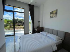 een slaapkamer met een bed en een groot raam bij Nine Hotel Gia Lai in Pleiku