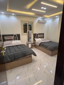 um quarto com 2 camas e um espelho em LAYAN LUXURY APARTMENT no Cairo
