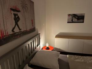 ein kleines Schlafzimmer mit einem Bett und einem roten Endtisch in der Unterkunft Ferienwohnung Grefenhof in Meerbusch