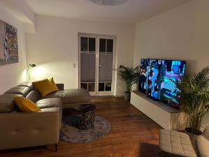 ein Wohnzimmer mit einem Sofa und einem Flachbild-TV in der Unterkunft Ferienwohnung Grefenhof in Meerbusch