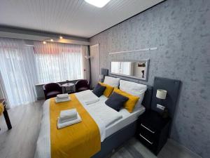 ein Schlafzimmer mit einem großen Bett und einer gelben Decke in der Unterkunft Strandnest Büsum in Büsum