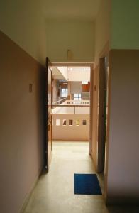 une chambre vide avec un couloir doté d'un tapis bleu dans l'établissement Chakalakkal Residency, à Sultan Bathery