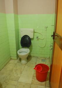 a bathroom with a toilet and a bucket at Chakalakkal Residency in Sultan Bathery