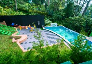 a backyard with a swimming pool in a yard at Areva Inn Munnar by VOYE HOMES in Munnar