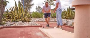 two men are playing on a rope in a garden at Mobil Home 6 personnes 40m2 Chez Isa in Torreilles