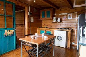 a kitchen with a table and a washing machine at les lys plaine des cafres in Le Tampon +19 photos
