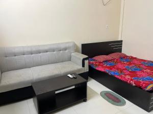 a small bedroom with a bed and a couch at Lakeview Apartments Homestay in Agartala