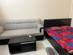 a living room with a bed and a couch at Lakeview Apartments Homestay in Agartala