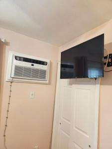 a room with a fan and a television on a wall at Luxury Colorful 3 Bd Unit 1 10 Mins From JFK in Brooklyn