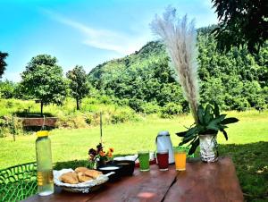 a picnic table with food and a basket of bread at UPASANA THE RIVER SIDE RESORT in Marchula