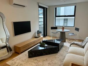 坎培拉的住宿－NEW BOUTIQUE 1bd Apt，客厅配有电视、沙发和桌子