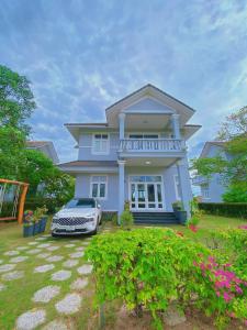 a white car parked in front of a house at Sealink Beach Villa PE48- PE69 in Ấp Bình Hưng
